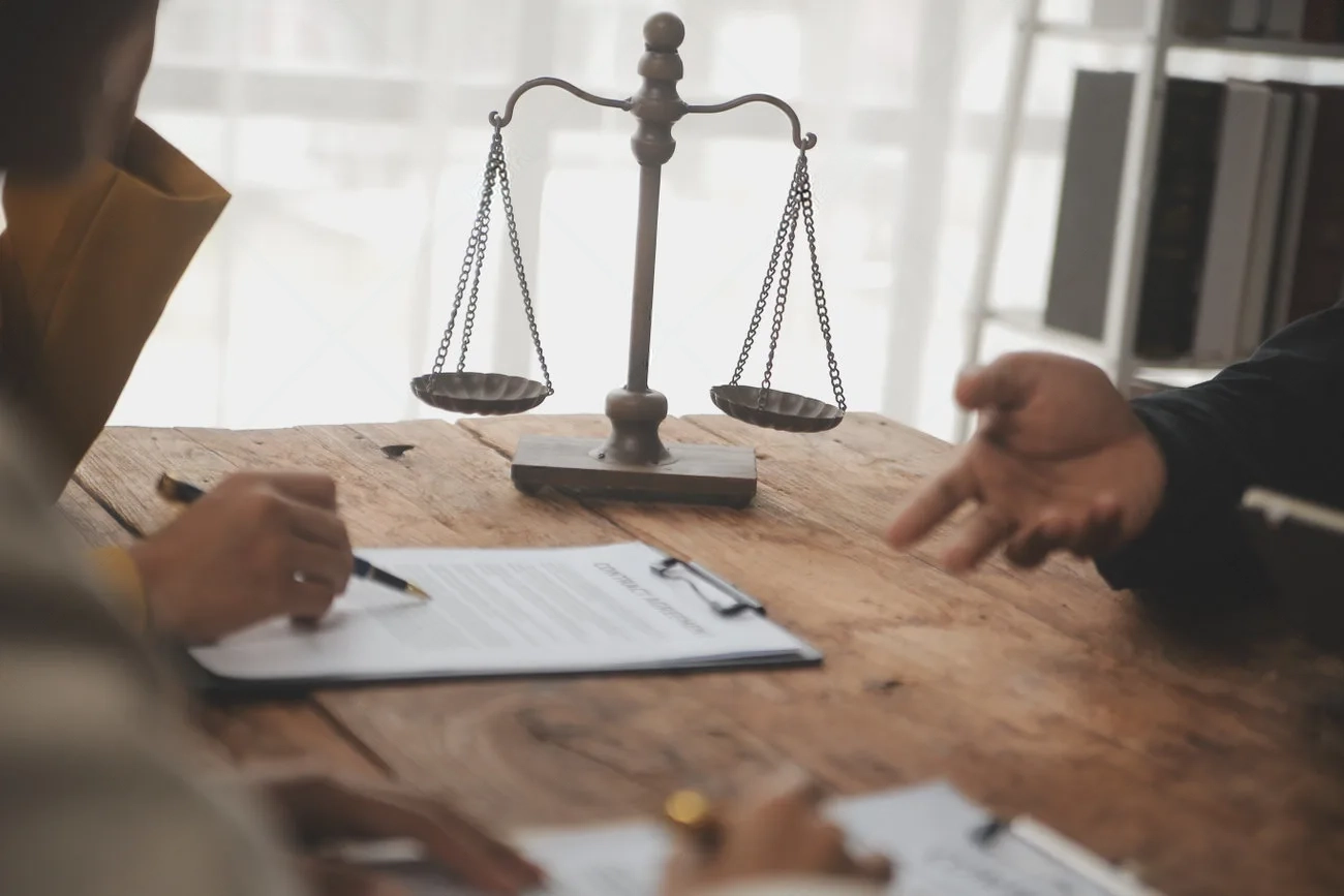 business-and-lawyers-discussing-contract-papers-with-brass-scale-on-desk-in-office-law-legal